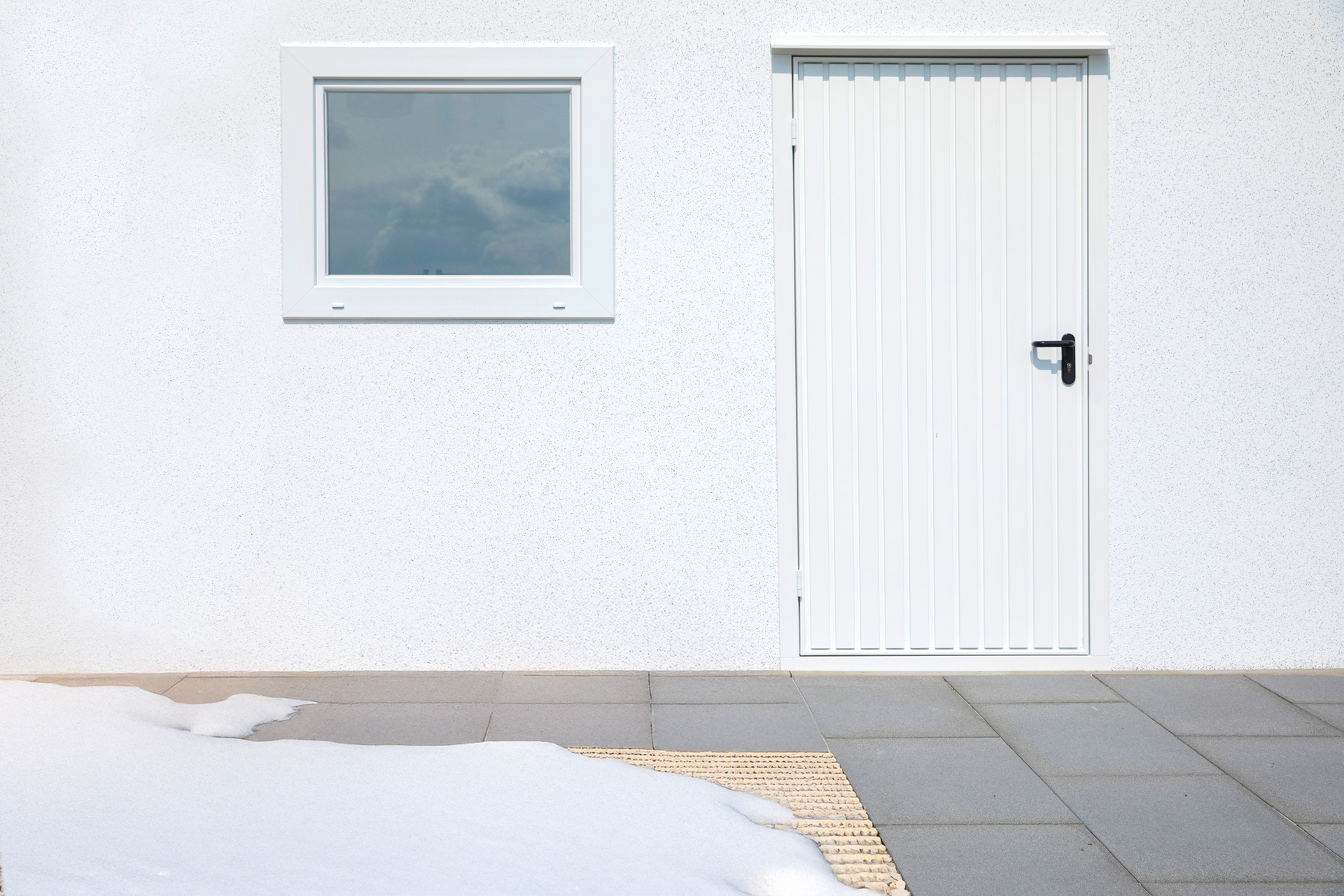 ZAPF Fertiggarage mit weißem Fenster und weißer Nebentür im Winter